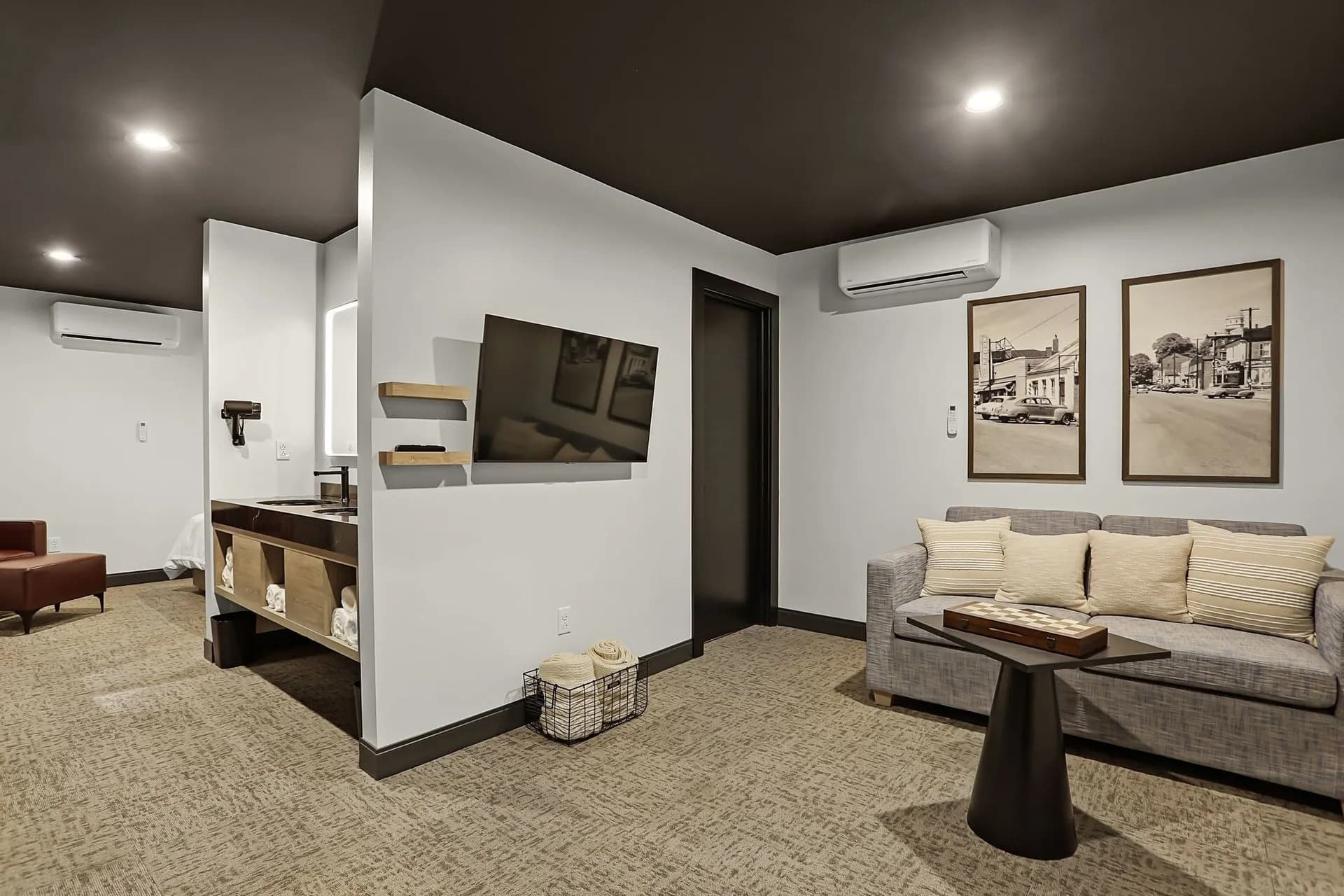Modern lounge area with a sofa, coffee table, wall-mounted television, and decorative artwork.