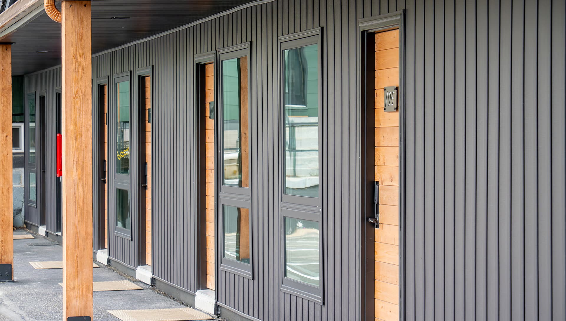 A row of modern, horizontal wooden-panelled doors with large windows.