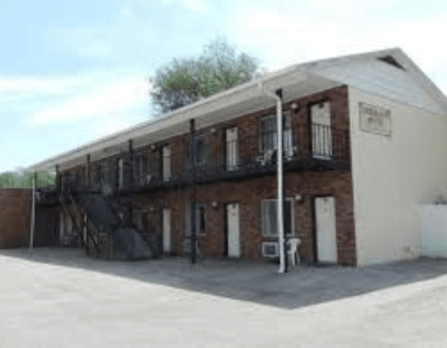 A two-story brick motel with external staircases and multiple doors.