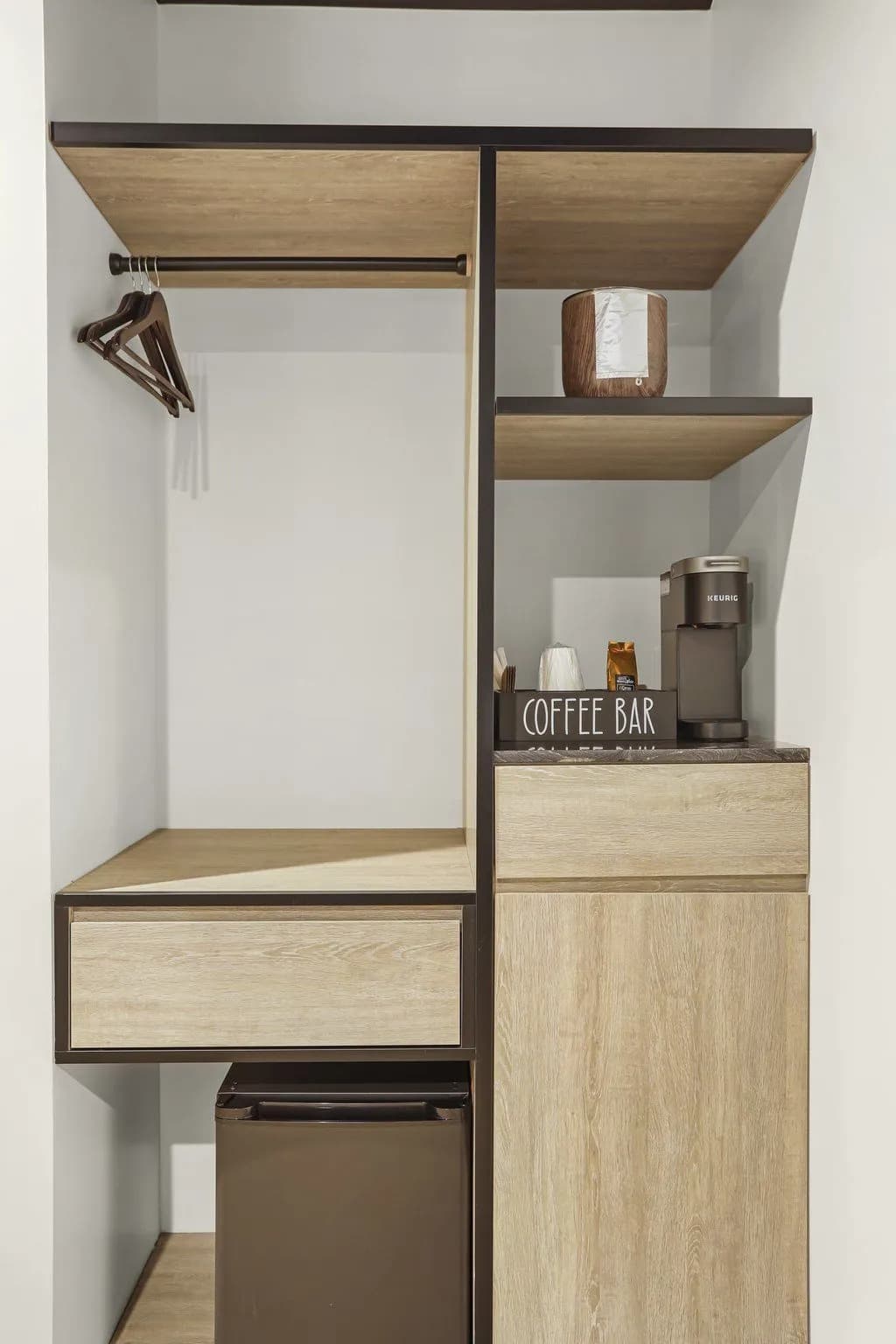A minimalist coffee bar area with wooden shelves, a coffee maker, and a small refrigerator.